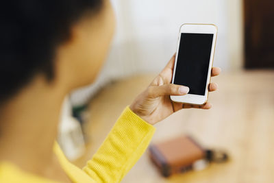 Young woman at home using smartphone