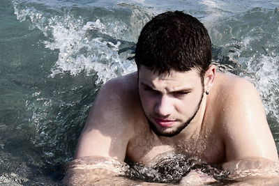 Portrait of young man swimming in pool