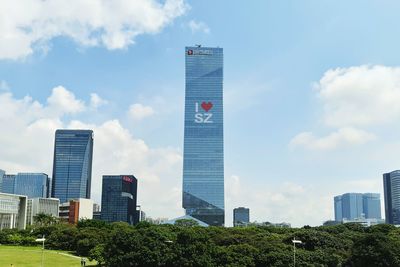 Buildings in city against cloudy sky