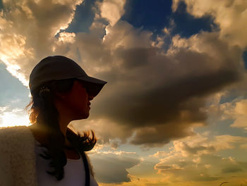 Low angle view of woman against sky during sunset