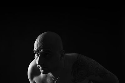 Shirtless man against black background