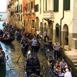 People in canal amidst buildings