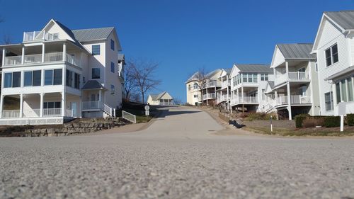 Empty road leading towards buildings