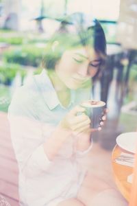 Young woman drinking coffee cup on table
