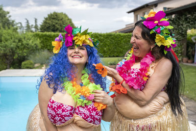 Rear view of woman standing by swimming pool against sky