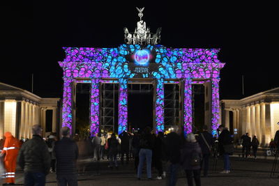 Group of people in front of illuminated building at night