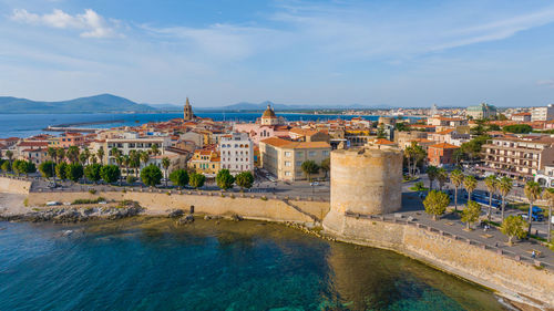 High angle view of townscape by sea against sky