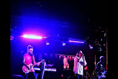 Rear view of people playing guitar at concert