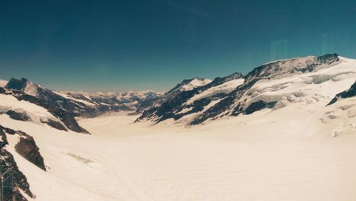 Scenic view of snowcapped mountains against clear sky