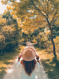 Rear view of woman standing in park during autumn