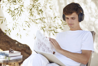 Full length of young man sitting outdoors