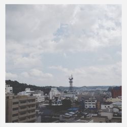 Buildings in city against cloudy sky