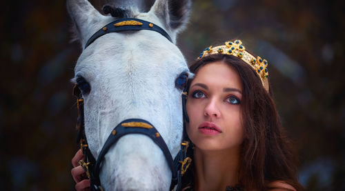 Close-up of young woman with horse standing outdoors