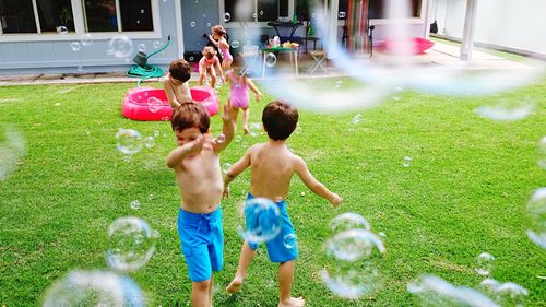 Full length of shirtless boy playing in yard