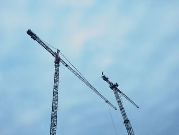 Low angle view of crane against sky