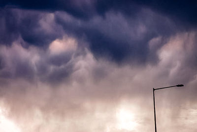 Low angle view of street light against cloudy sky