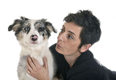 Portrait of man with dog against white background