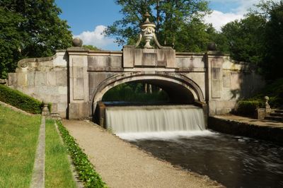 Arch bridge over river against sky