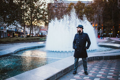 Full length of man standing on fountain in city