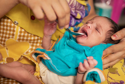 Cropped hand of woman holding baby