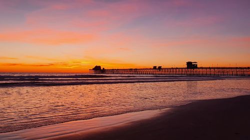 Scenic view of beach against sky during sunset