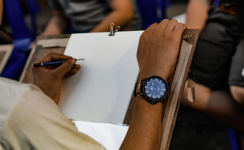 Cropped image of man sketching on paper