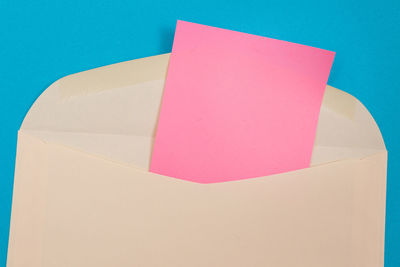 High angle view of multi colored paper on table against blue background