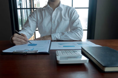 Midsection of man sitting on table