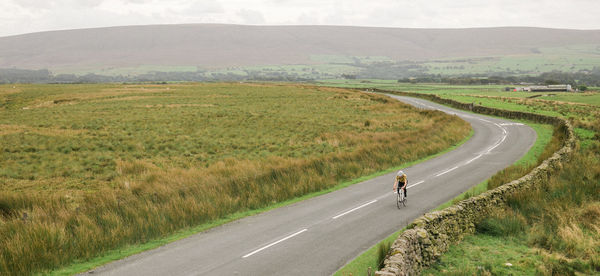 Scenic view of road passing through field