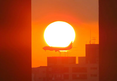 Illuminated lamp against orange sky during sunset