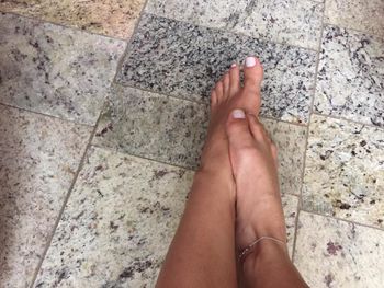 Low section of woman feet on tiled floor