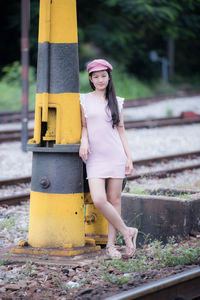 Portrait of woman standing on railroad track