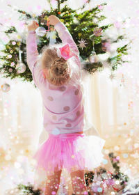 Rear view of girl decorating christmas tree