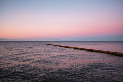 Scenic view of sea against clear sky at sunset