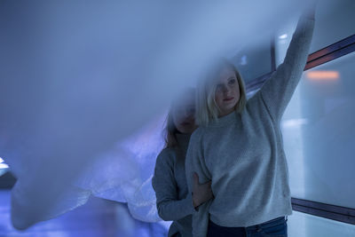 Young woman with friend holding plastic