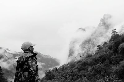 Man looking at mountains against sky