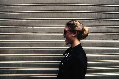 Woman standing by shutter