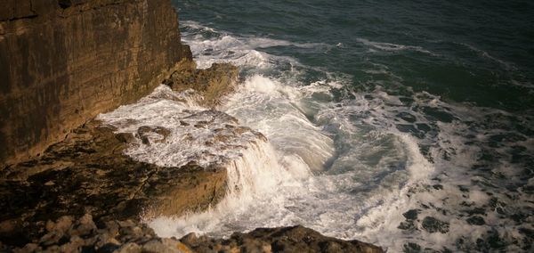 High angle view of waves crashing on rocks