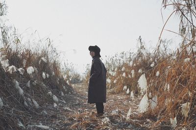 Man standing on field against clear sky during winter