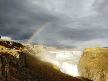 Scenic view of rainbow over landscape against sky