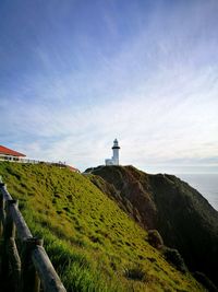 Lighthouse by sea against sky