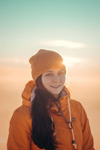 Traveller with pleasant smile in a distinctive yellow jacket stands on top of hill in polish beskydy