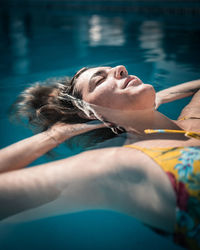 Portrait of woman lying in swimming pool