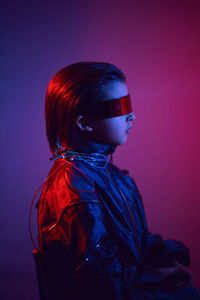 Portrait cyberpunk boy child in vr glasses in blue and red tones. game, virtual reality