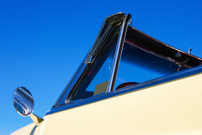 Low angle view of crane against clear blue sky