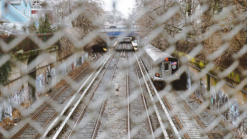 High angle view of railway tracks seen through fence