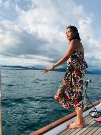 Side view of woman looking at sea against sky