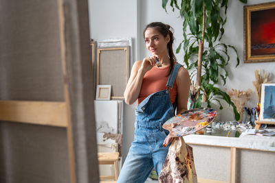 Portrait of young woman standing at home