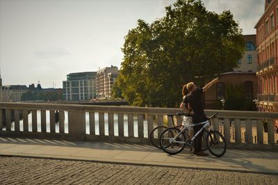 Man riding bicycle on bridge in city