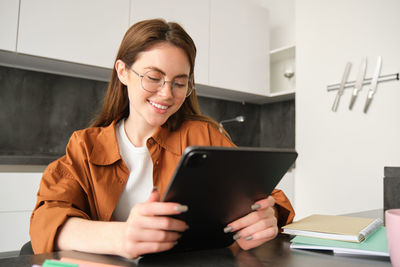 Young woman using digital tablet while working at office